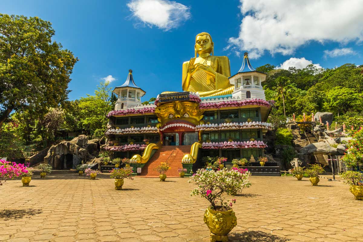 Golden Temple of Dambulla in Sri Lanka with large golden Buddha statue and decorated temple entrance