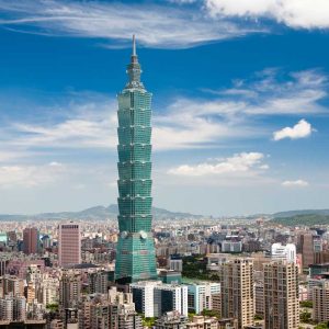 Taipei 101 skyscraper towering over Taipei cityscape under blue sky with clouds