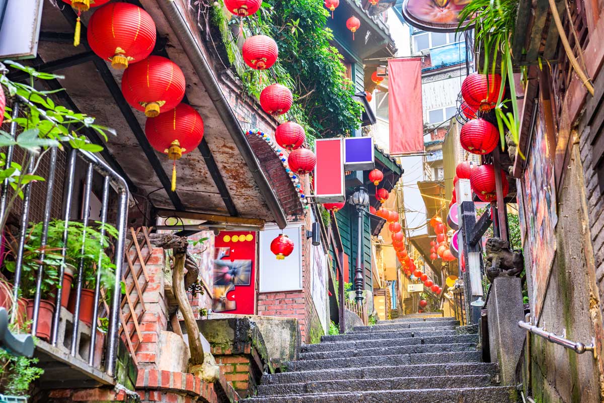 Narrow stone stairway decorated with red lanterns and shops