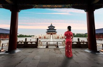 Woman in red qipao inside pavilion facing the Temple of Heaven in Beijing China
