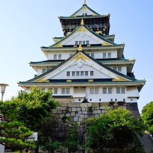 Osaka Castle with ornamental roof and stone base under clear blue sky