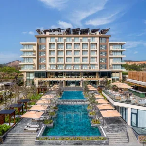 Exterior view of Radisson Resort Mui Ne with pool and outdoor seating under umbrellas