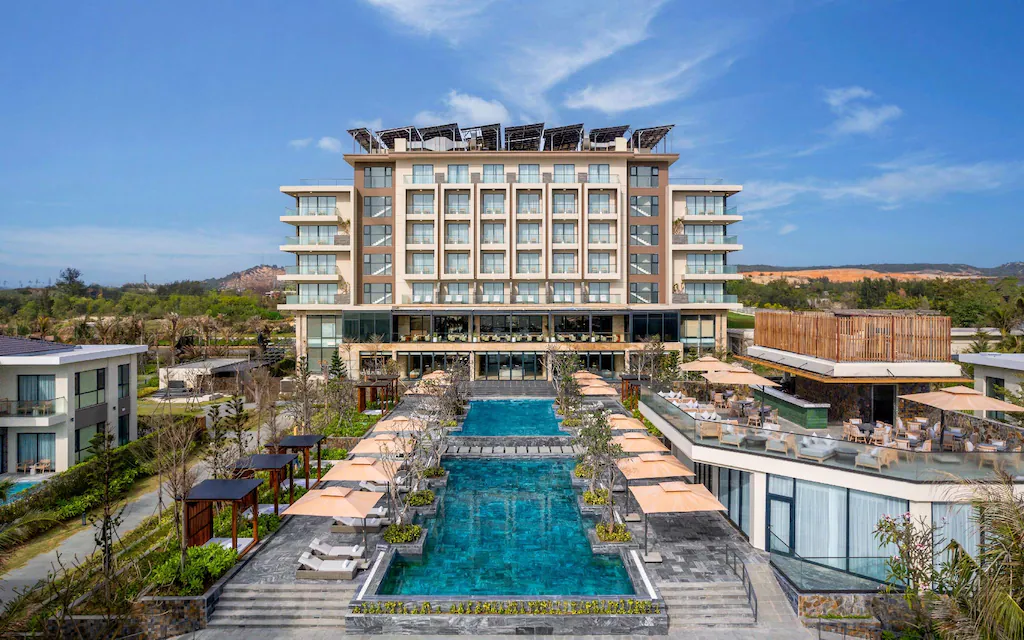 Exterior view of Radisson Resort Mui Ne with pool and outdoor seating under umbrellas