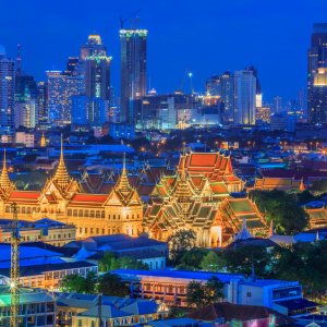 Grand Palace in Bangkok lit up at night with city skyline in background