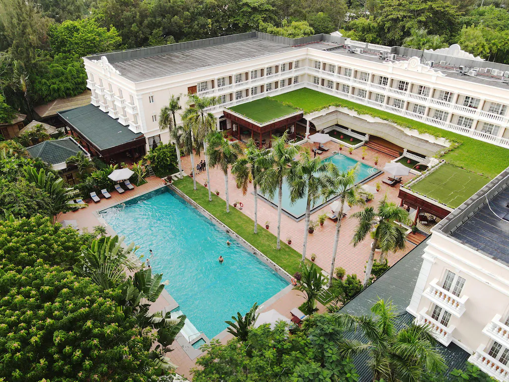 Aerial view of Victoria Can Tho Resort with swimming pool and palm trees