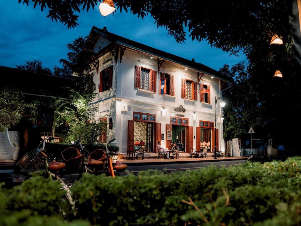 3 Nagas Hotel exterior at night with outdoor seating and hanging lanterns