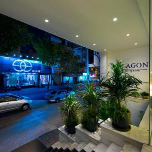 Night view of Alagon Saigon Hotel & Spa entrance with city street and illuminated stores
