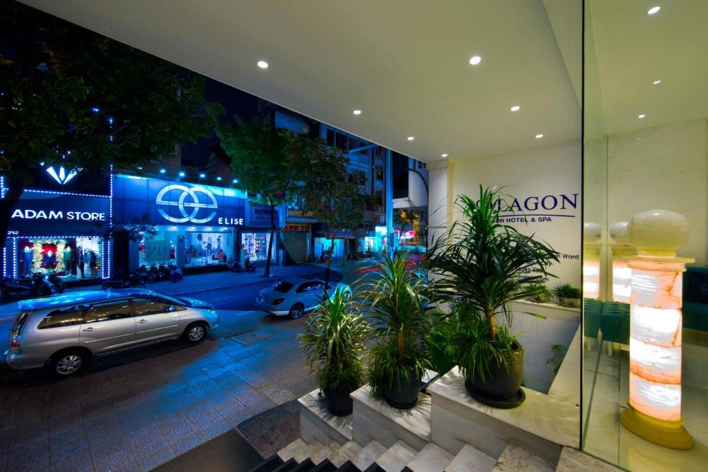 Night view of Alagon Saigon Hotel & Spa entrance with city street and illuminated stores