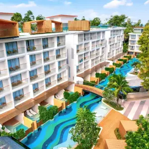 Modern resort with winding blue pool and tropical landscaping