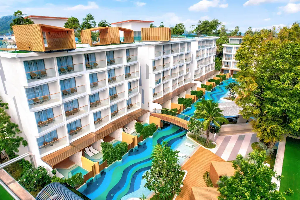 Modern resort with winding blue pool and tropical landscaping