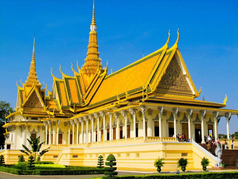 Royal Palace building with golden roofs and tourists in Phnom Penh, Cambodia