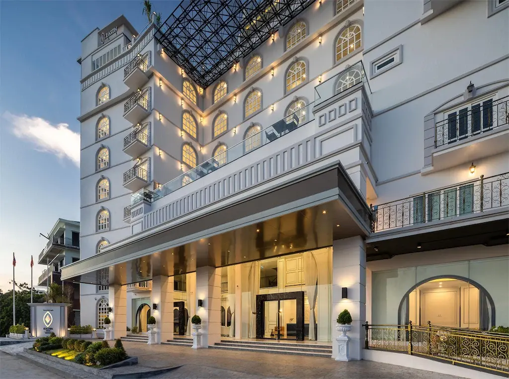 Exterior façade of Eastin Hotel Vientiane with illuminated arched windows and glass roof.