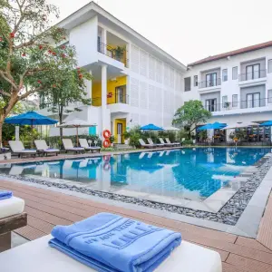 Outdoor swimming pool with sun loungers and umbrellas at Emm Hotel Hoi An