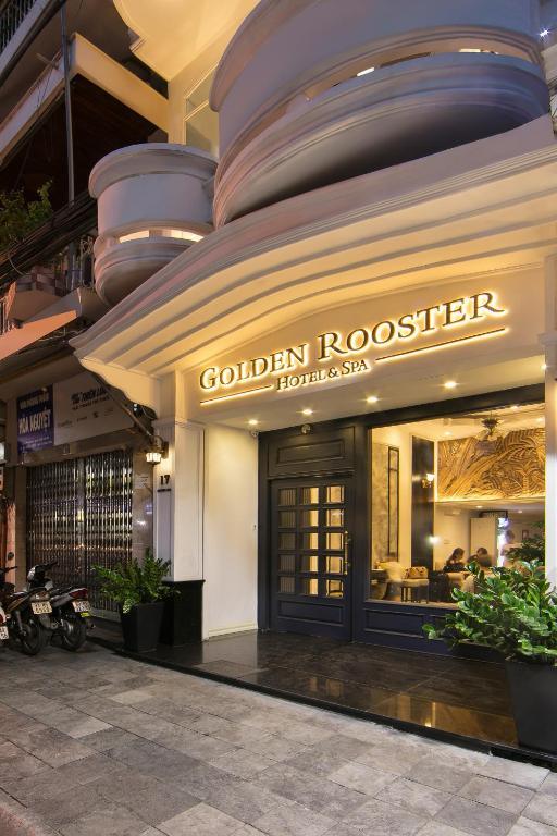 Golden Rooster Hotel & Spa entrance lit up at night with seating area inside