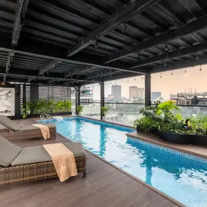 Covered rooftop swimming pool with lounge chairs and city buildings in background