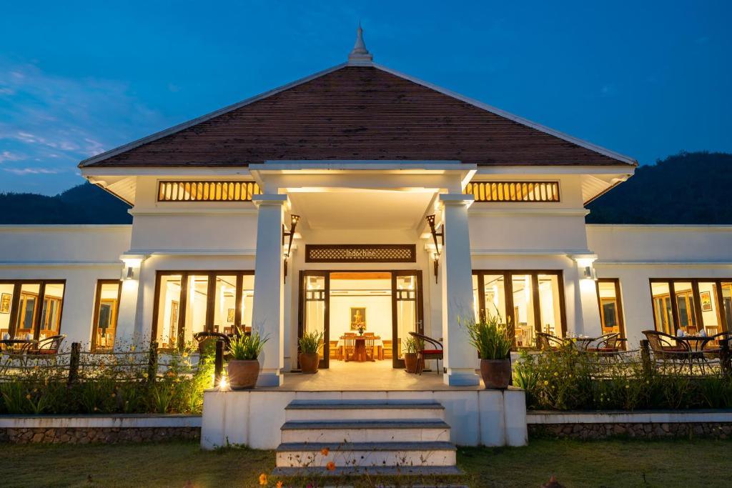 Le Grand Pakbeng resort entrance lit at twilight with outdoor seating and garden