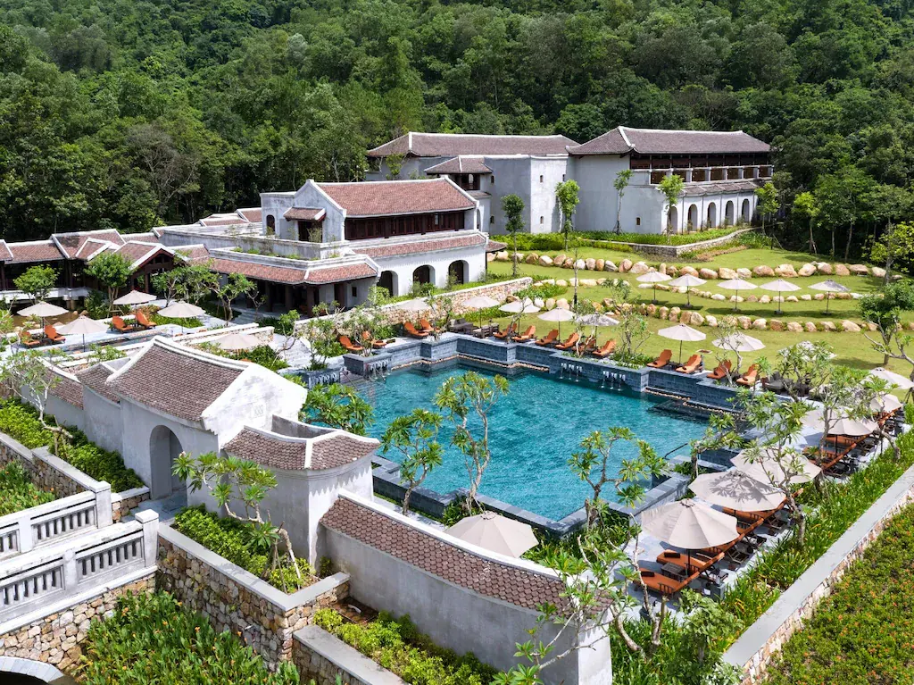 Luxury resort with outdoor pool, sun loungers and greenery in forest setting