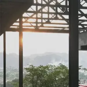 Wooden roof structure framing green trees and distant hills at M Roof Ipoh