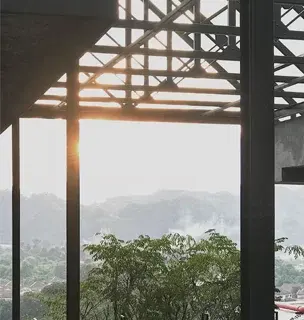 Wooden roof structure framing green trees and distant hills at M Roof Ipoh