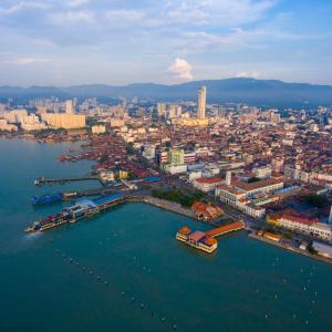 Aerial view of coastal city with piers and urban buildings under partly cloudy sky