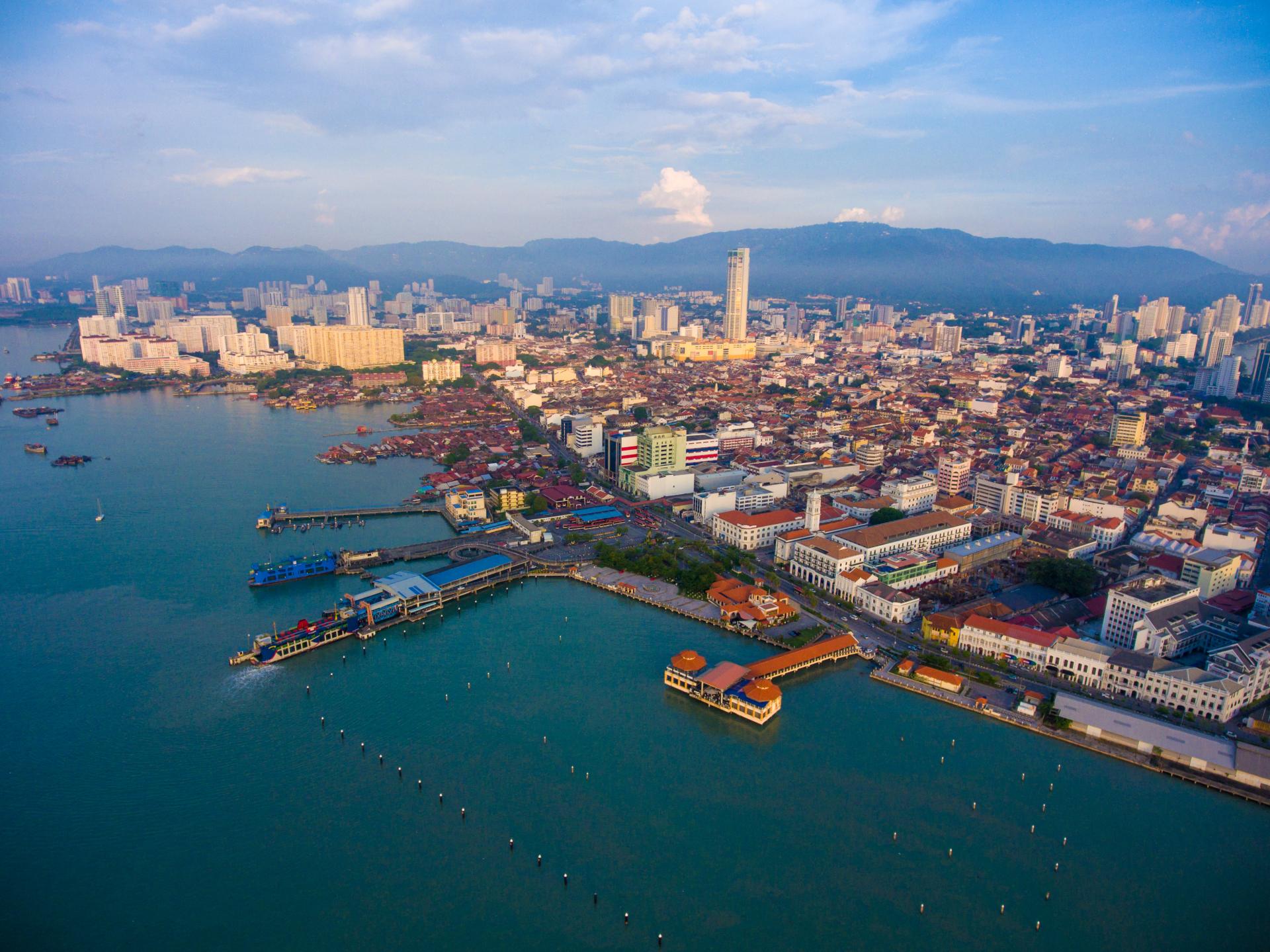 Aerial view of coastal city with piers and urban buildings under partly cloudy sky