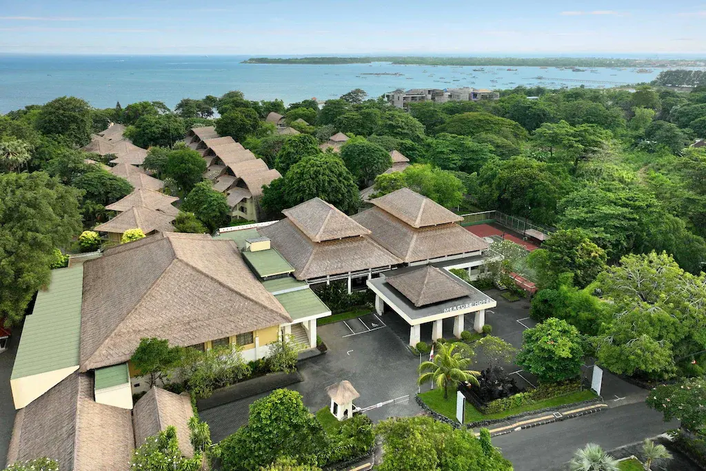Aerial view of Mercure Sanur resort surrounded by trees with ocean in background
