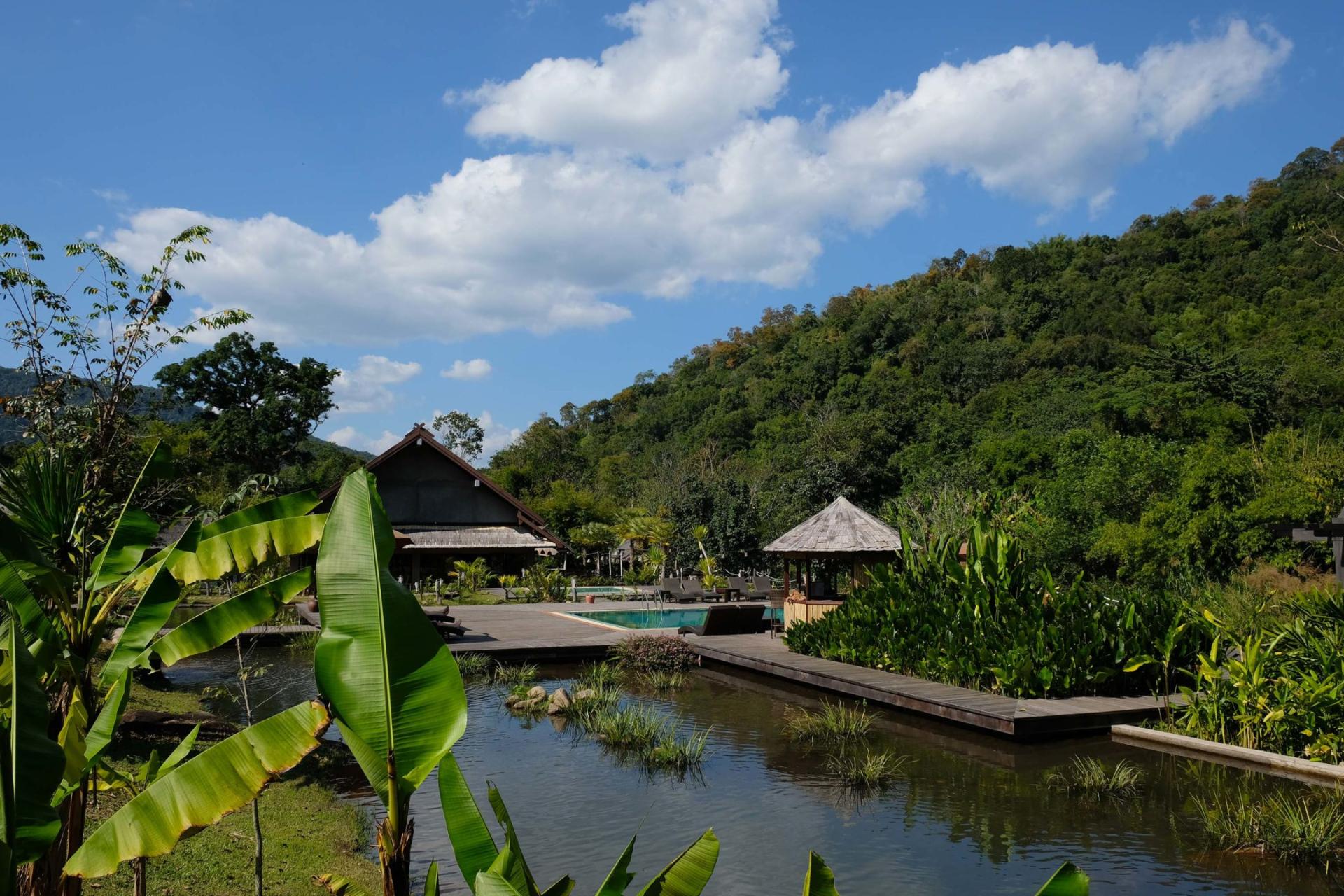 Nam Kat Yorla Pa resort with pool, wooden hut, and lush green hills