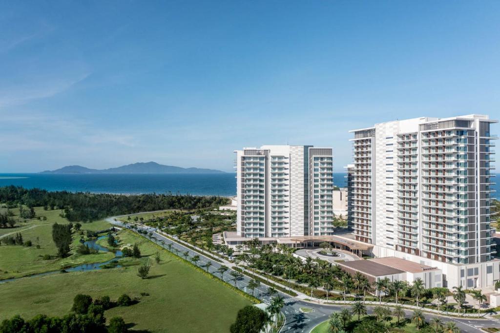 High-rise modern hotel by the ocean with green landscape and blue sky