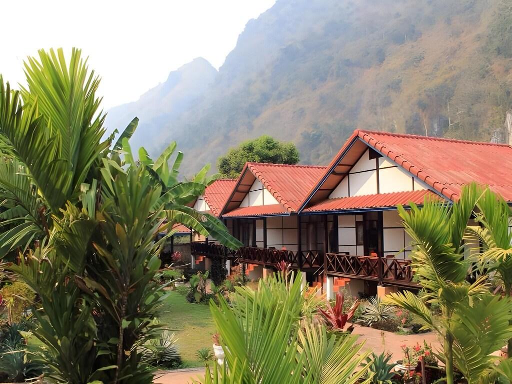 Tropical bungalows at Phaxang Resort with greenery and mountains behind