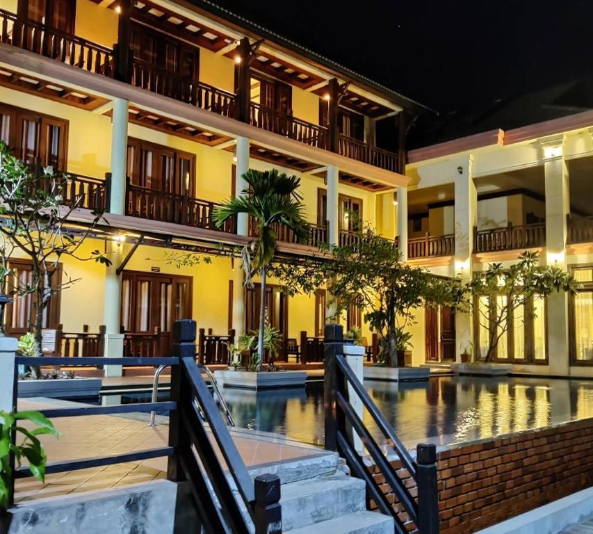 Night view of Pon Arena Hotel exterior with pool and illuminated balconies