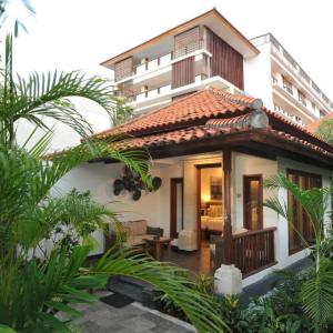 Villa-style hotel room exterior with tropical plants and warm lighting
