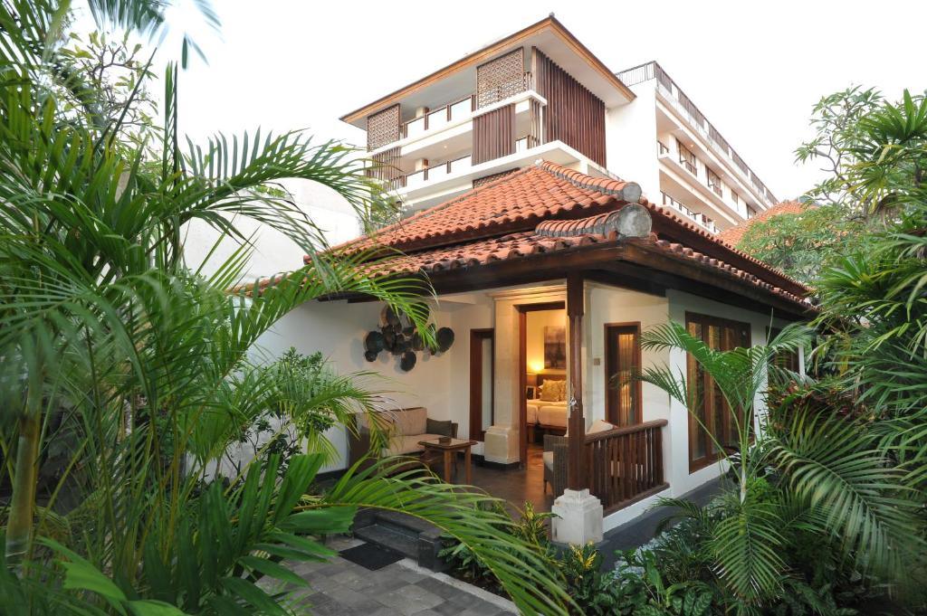 Villa-style hotel room exterior with tropical plants and warm lighting