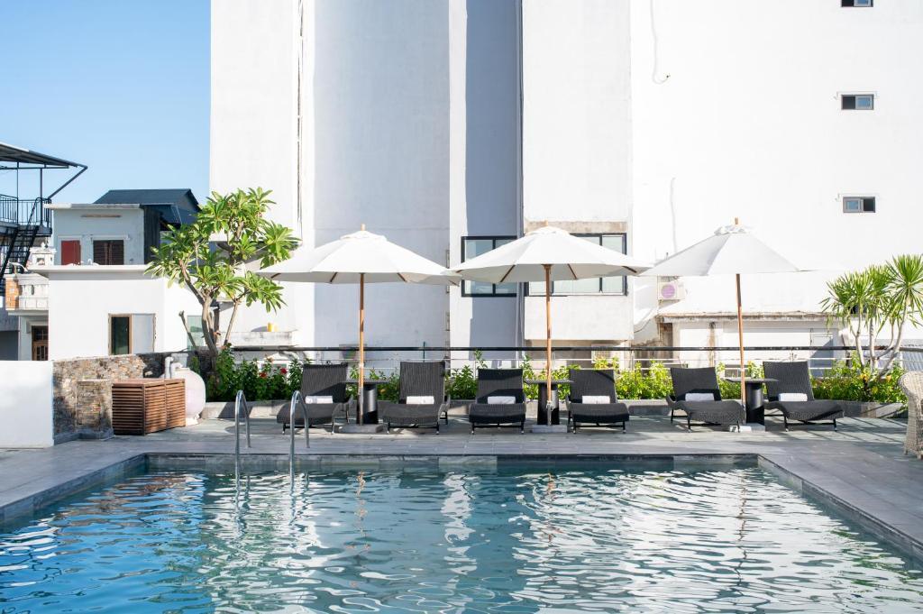 Poolside at Rosaleen Boutique Hotel with sun loungers and white umbrellas