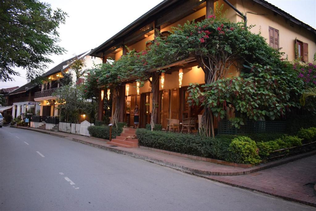 Street view of Sala Prabang Hotel with wooden facade and evening lights