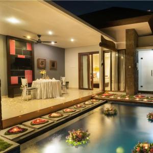 Villa patio with decorated pool and outdoor dining setup at night