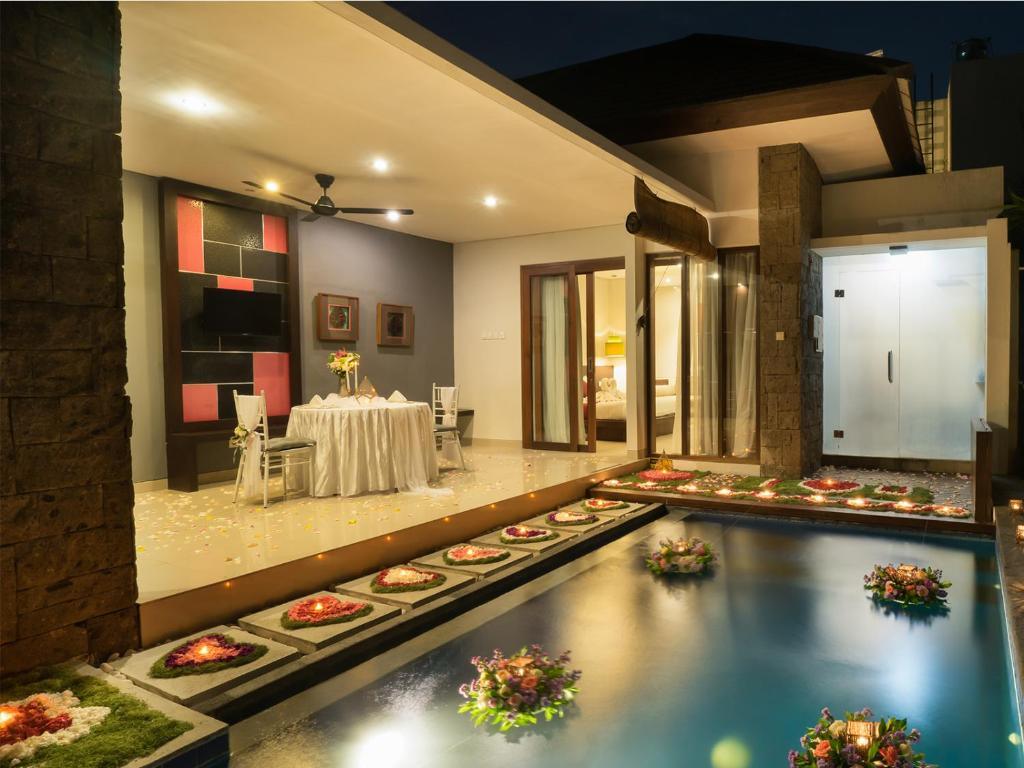Villa patio with decorated pool and outdoor dining setup at night