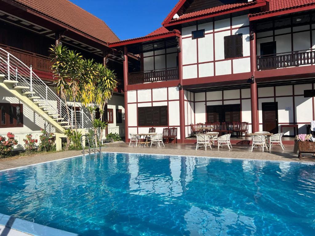 Outdoor swimming pool and patio at Senesothxuen Hotel with traditional architecture