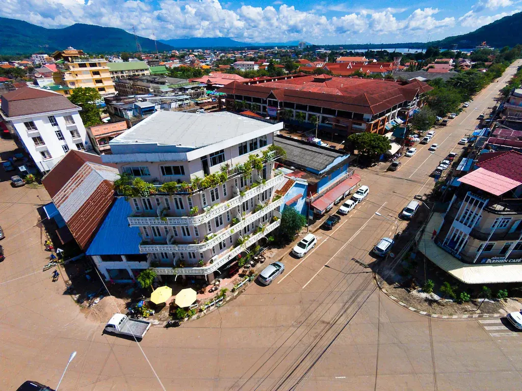 Aerial view of Sisouk Residence at an urban street intersection with cars and buildings