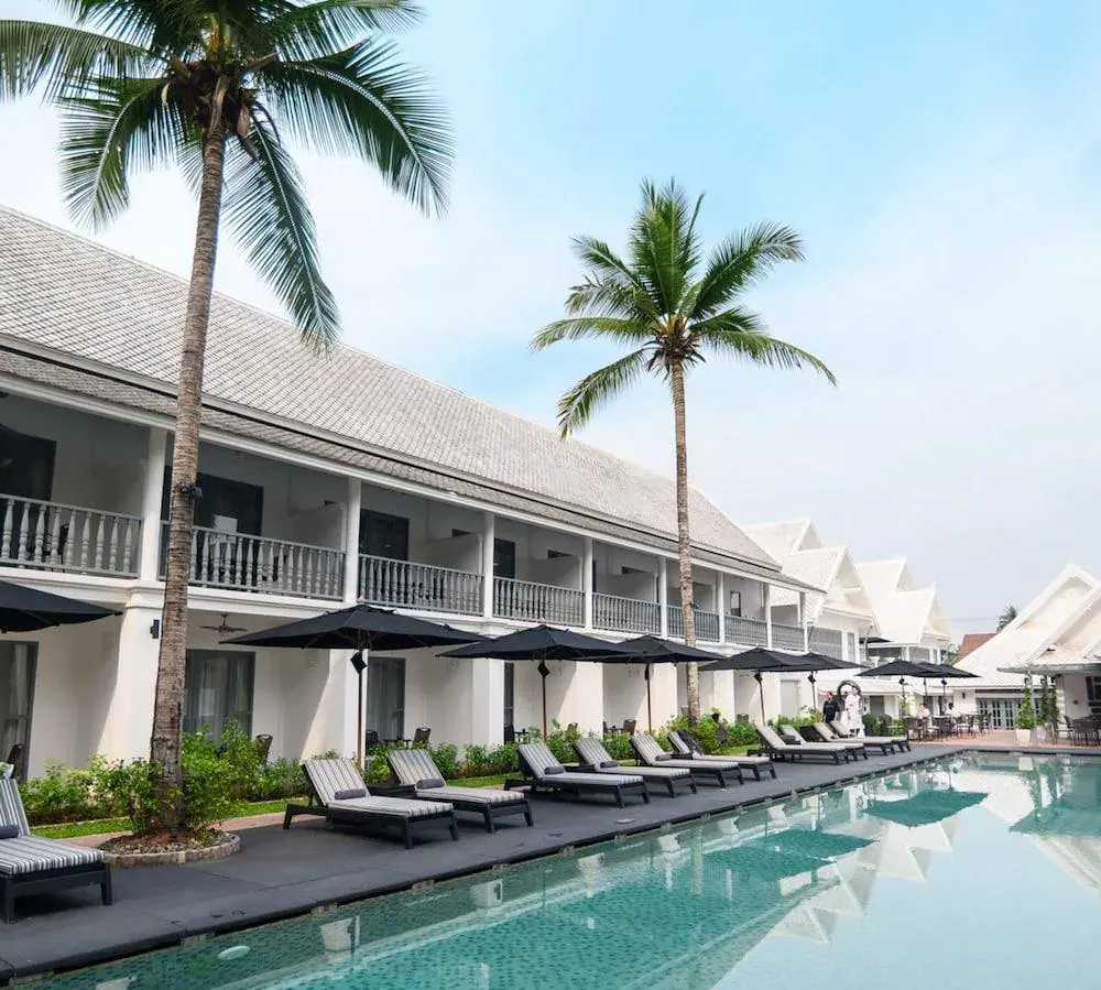 Outdoor pool area at Souphattra Hotel with loungers and palm trees