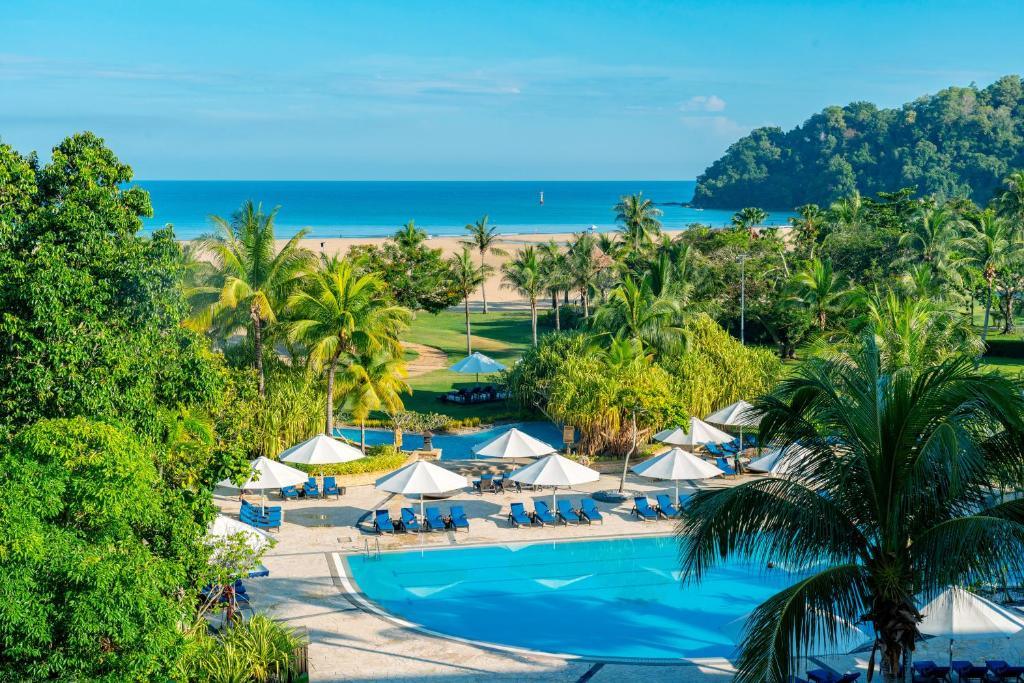 Resort pool with umbrellas overlooking tropical beach and ocean