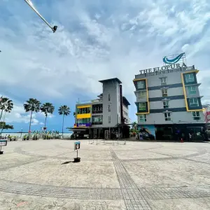 The Elopura Hotel near palm trees and plaza under partly cloudy sky